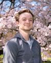 Photo of Erik in front of cherry blossoms. 